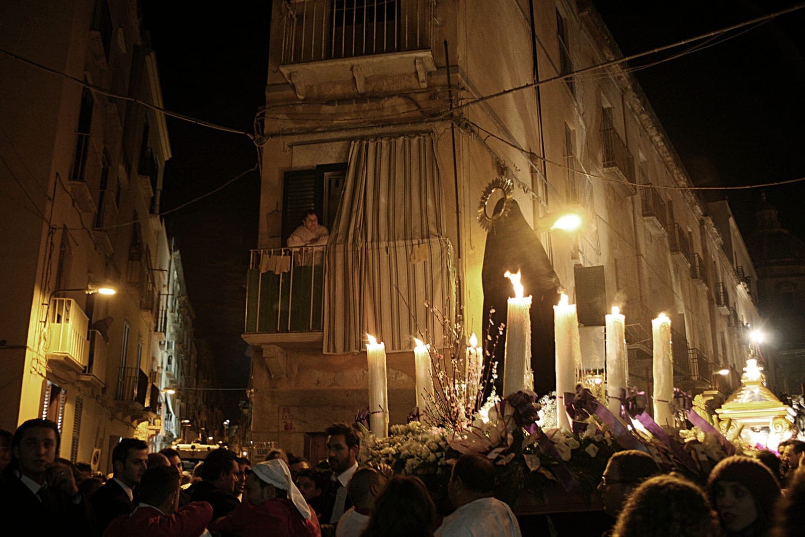 A candlelit gathering outside a Sicilian building